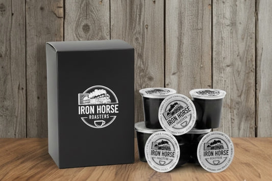 Iron Horse Roasters coffee pods and packaging on a wooden surface with a wooden background